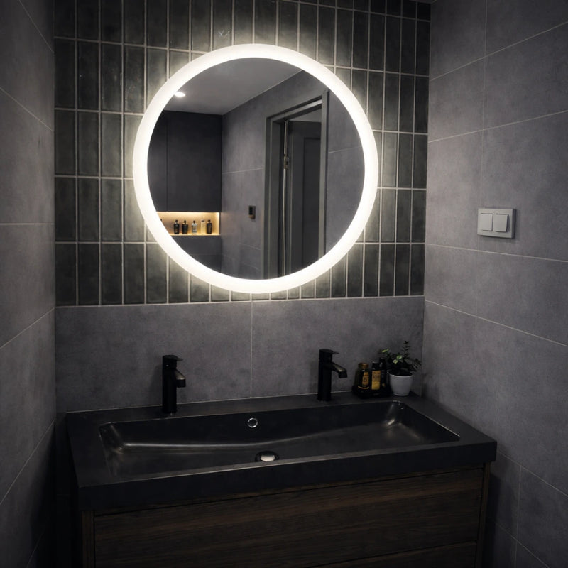 Bathroom with a round illuminated mirror above a sink