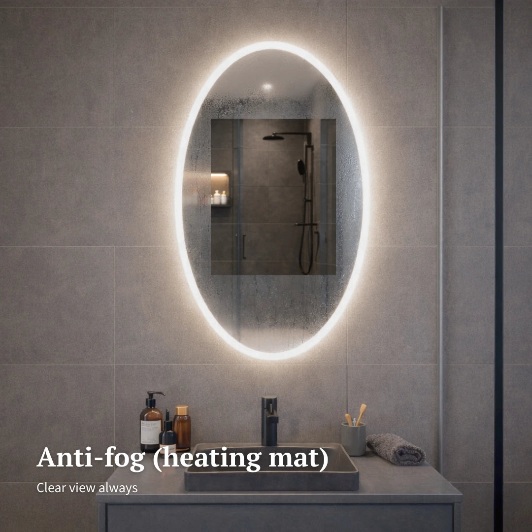 Bathroom with a large oval mirror featuring an anti-fog heating mat, showing clear reflection.